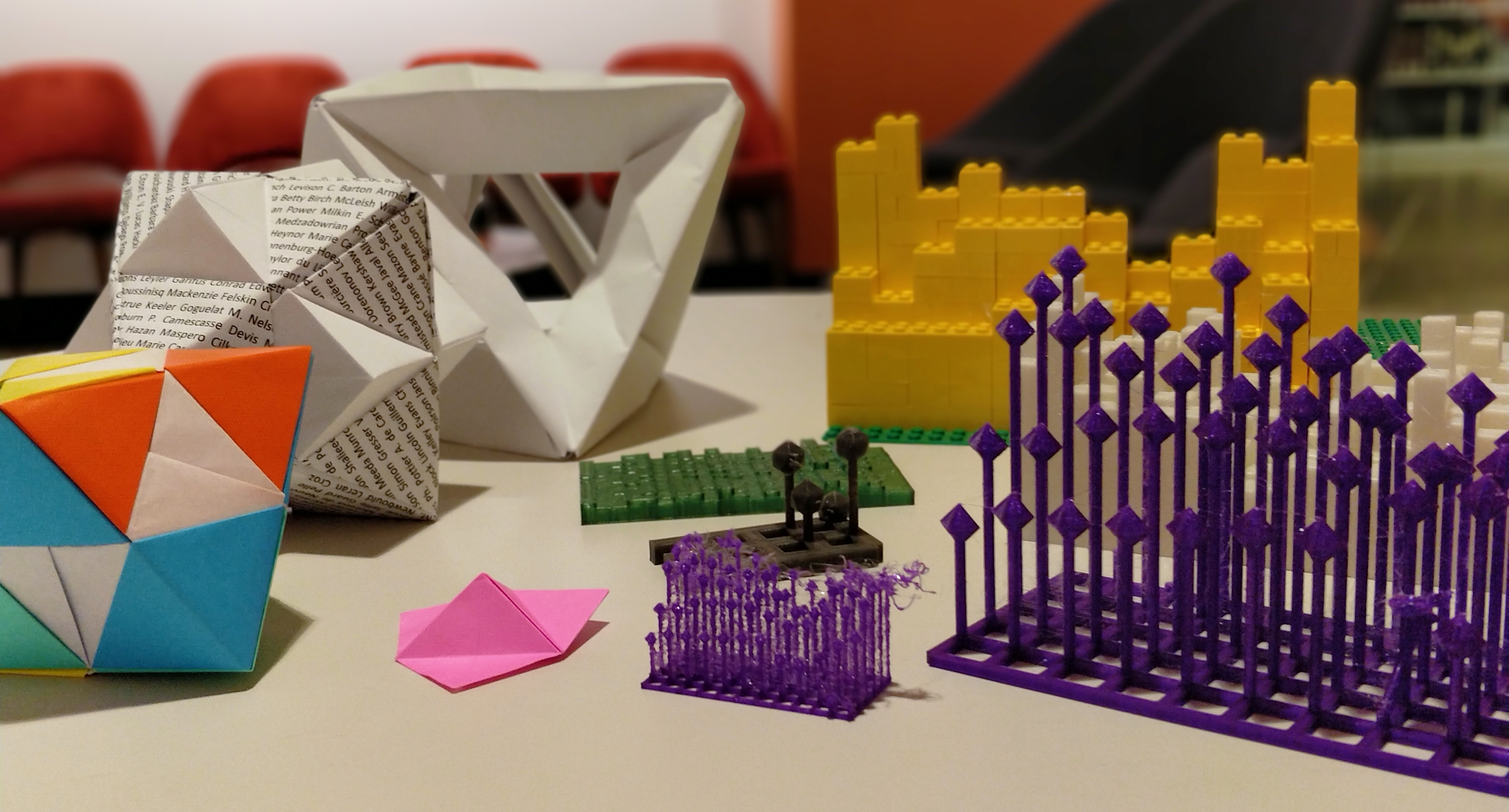 origami, 3d print, and lego prototypes displayed together on a table